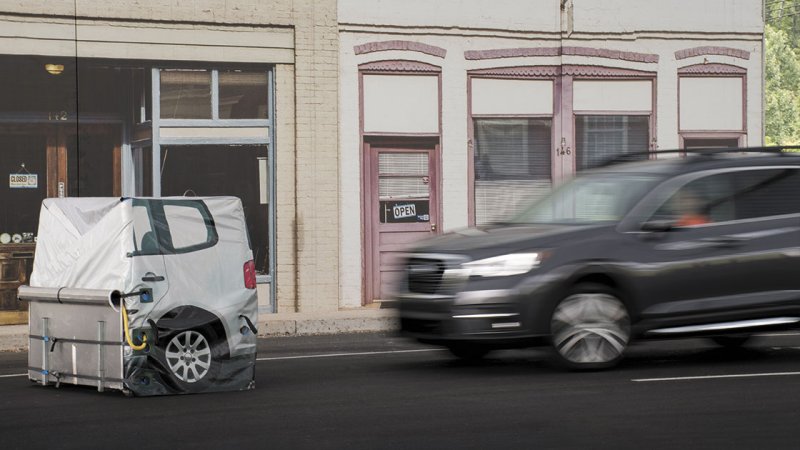 An SUV undergoes an automatic emergency braking system test, speeding into a dummy obstacle.
