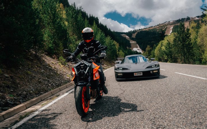 KTM motorcycle and X-Bow car on a forested road.