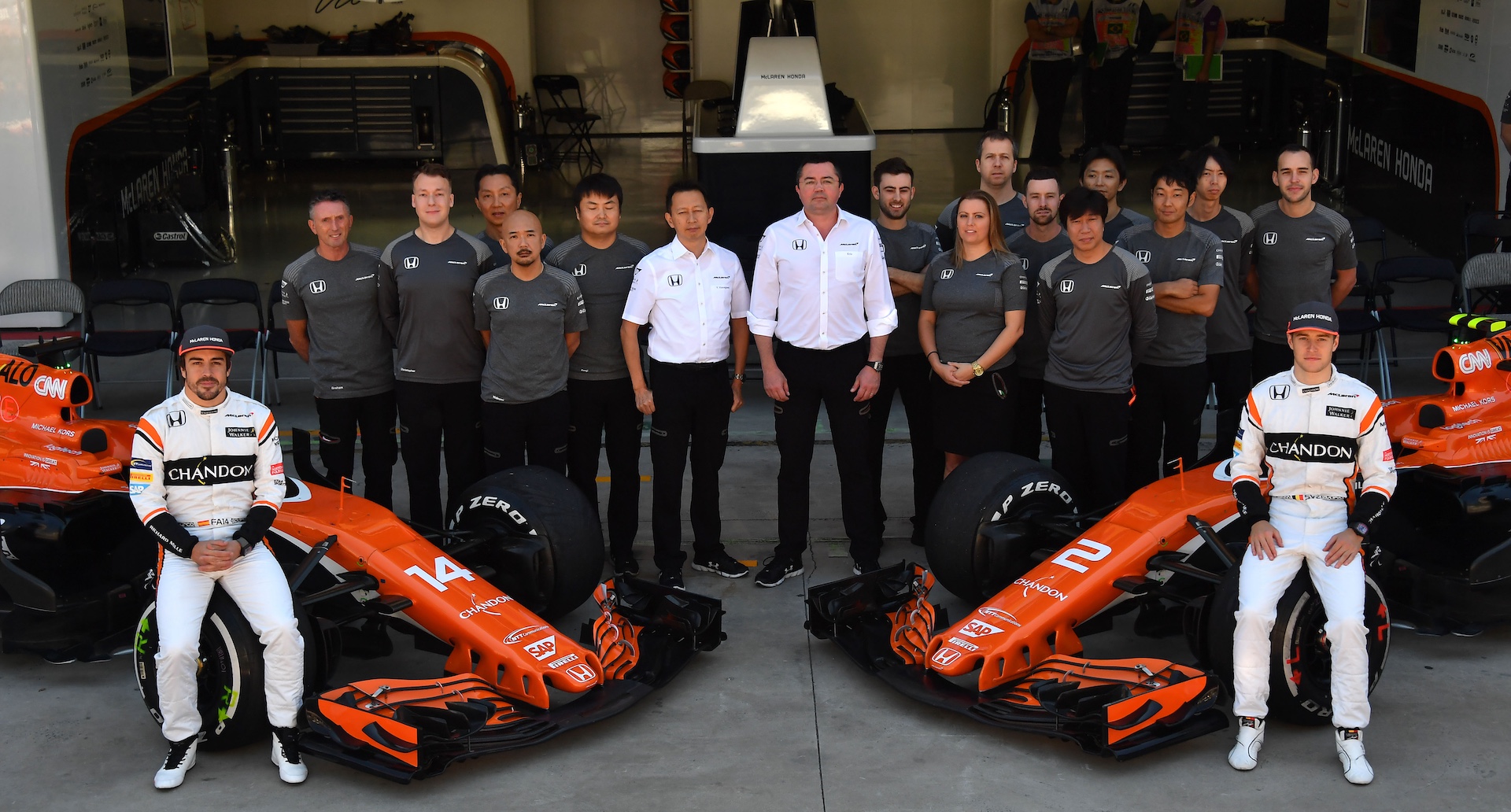 McLaren's Spanish driver Fernando Alonso (L) and Belgian driver Stoffel Vandoorne (R) pose with part of the McLaren team in the pits before the start of the Brazilian Formula One Grand Prix at the Interlagos circuit in Sao Paulo, Brazil, on November 12, 2017. / AFP PHOTO / Nelson ALMEIDA (Photo credit should read NELSON ALMEIDA/AFP via Getty Images)